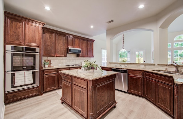 1840 Leela Springs Dr, Conroe, TX 77304 - kitchen with light stone counters, visible vents, a sink, light wood-style flooring, and appliances with stainless steel finishes