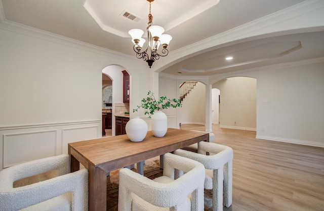 1840 Leela Springs Dr, Conroe, TX 77304 - dining area with a chandelier, arched walkways, a tray ceiling, light wood-style flooring, and visible vents