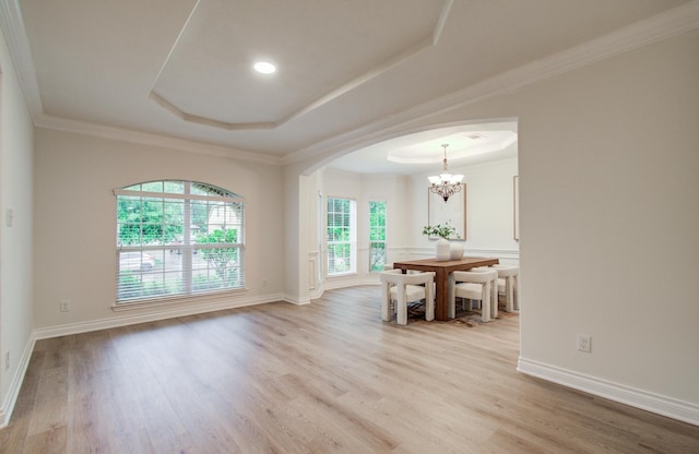 1840 Leela Springs Dr, Conroe, TX 77304 - unfurnished dining area with light wood finished floors, an inviting chandelier, arched walkways, and a raised ceiling
