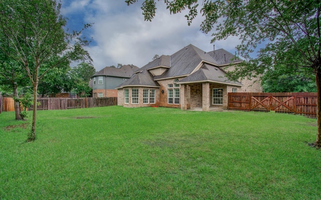 1840 Leela Springs Dr, Conroe, TX 77304 - rear view of property featuring brick siding, a lawn, and a fenced backyard