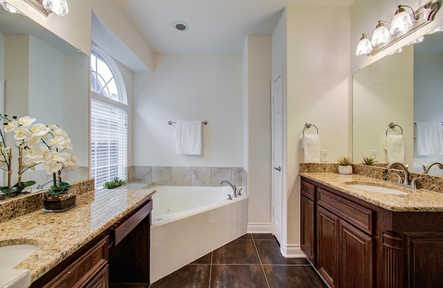 1840 Leela Springs Dr, Conroe, TX 77304 - bathroom featuring a garden tub, two vanities, tile patterned flooring, and a sink