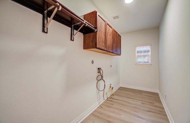 1840 Leela Springs Dr, Conroe, TX 77304 - clothes washing area featuring visible vents, light wood-type flooring, hookup for a washing machine, baseboards, and cabinet space