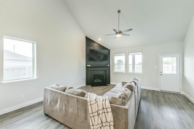 20002 Roan Ardennes Ln, Tomball, TX 77377 - living room featuring ceiling fan, vaulted ceiling, wood finished floors, baseboards, and a large fireplace