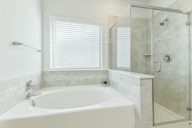 bathroom featuring a bath and a stall shower