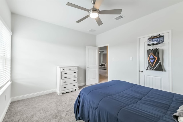 bedroom with baseboards, visible vents, light colored carpet, and multiple windows