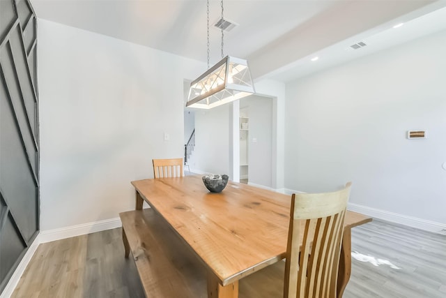 dining space with baseboards, wood finished floors, and visible vents