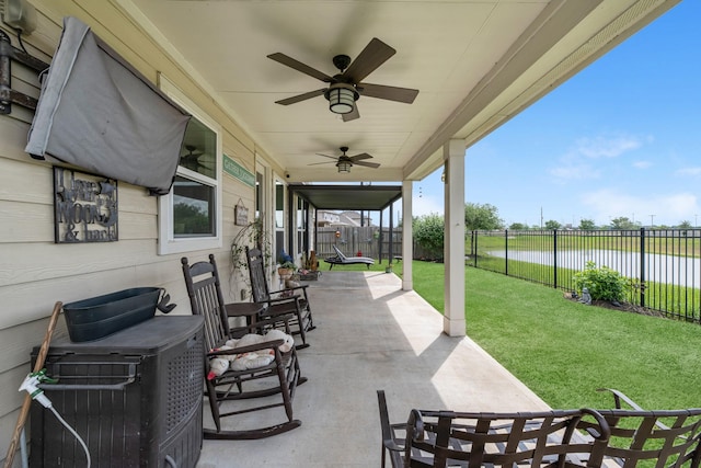 view of patio / terrace with a fenced backyard, a water view, and a ceiling fan