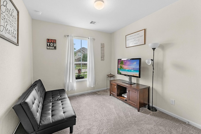 sitting room featuring visible vents, baseboards, and light carpet