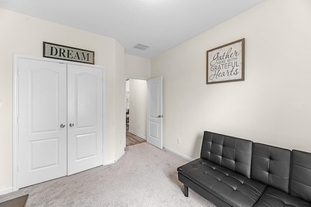 living area featuring carpet floors, visible vents, and baseboards
