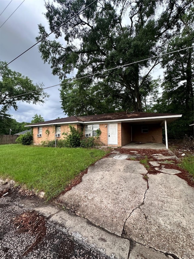 ranch-style home with a front lawn, a carport, fence, brick siding, and aphalt driveway