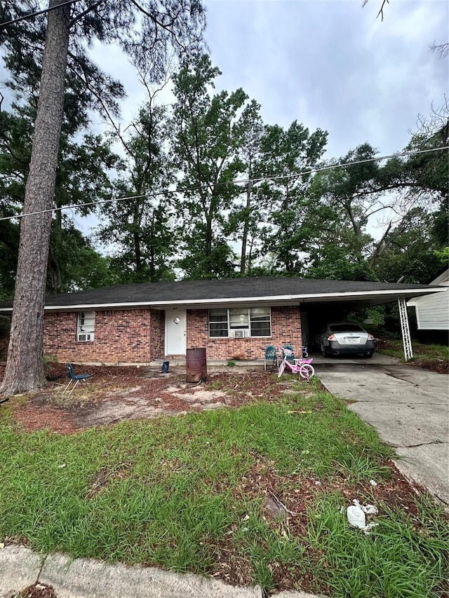 ranch-style home with concrete driveway, brick siding, and an attached carport