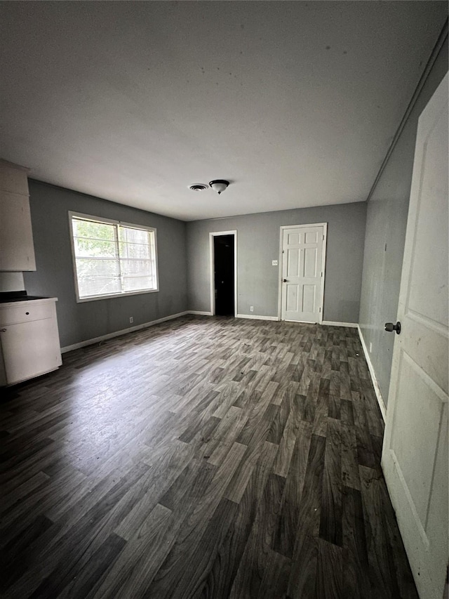 interior space with visible vents, baseboards, and dark wood-style flooring