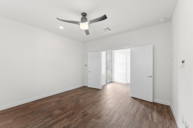 spare room with visible vents, a ceiling fan, baseboards, and wood finished floors