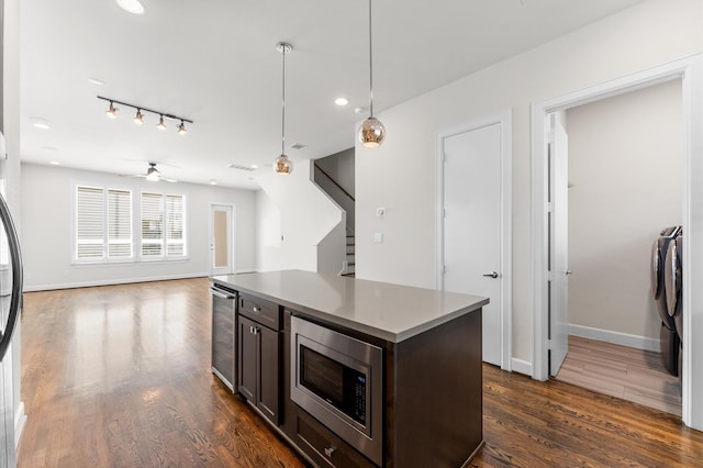 kitchen with dark brown cabinets, stainless steel microwave, dark wood-type flooring, wine cooler, and pendant lighting
