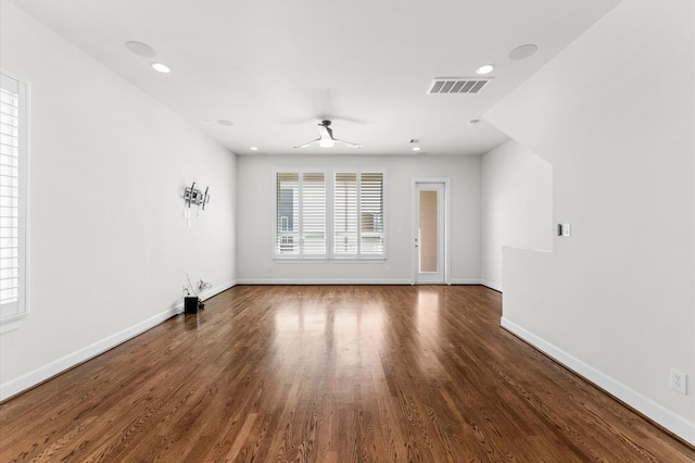 spare room featuring baseboards, ceiling fan, and wood finished floors