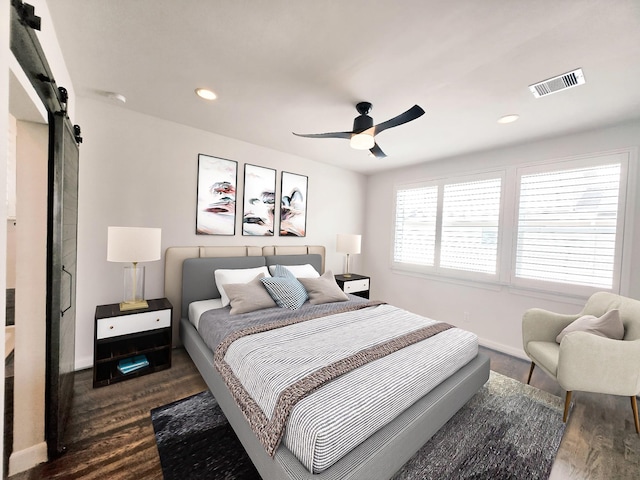 312 Eado Park Cir, Houston, TX 77020 - bedroom with a barn door, dark wood-type flooring, baseboards, recessed lighting, and ceiling fan