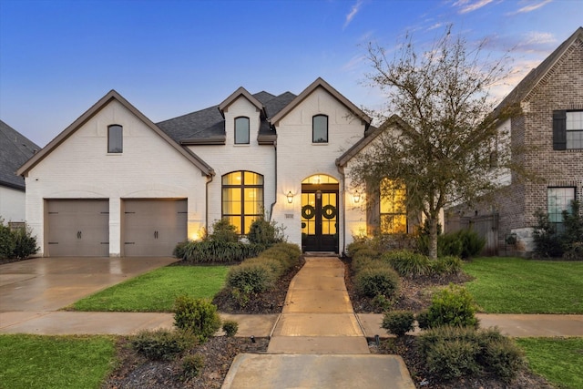 8818 Laurel Crest Dr, Missouri City, TX 77459 - french provincial home with a shingled roof, a front lawn, concrete driveway, french doors, and brick siding