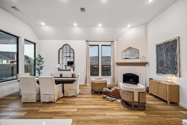 8818 Laurel Crest Dr, Missouri City, TX 77459 - living area featuring lofted ceiling, wood finished floors, visible vents, and a fireplace