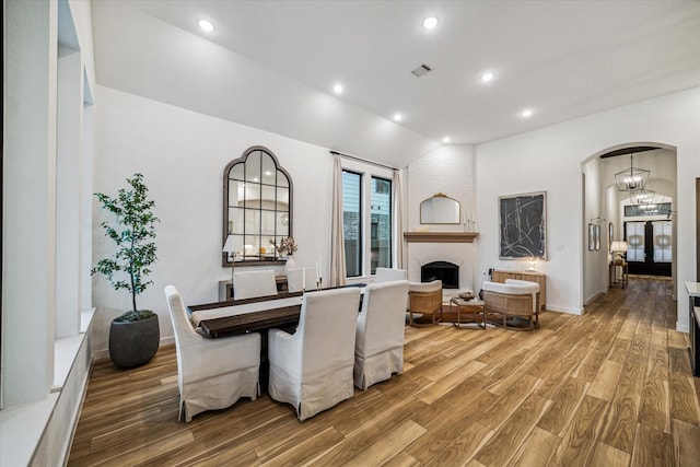 8818 Laurel Crest Dr, Missouri City, TX 77459 - dining area with arched walkways, visible vents, recessed lighting, lofted ceiling, and wood finished floors