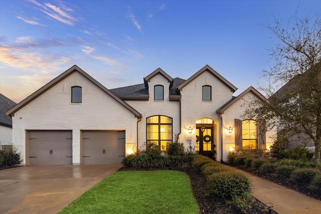 8818 Laurel Crest Dr, Missouri City, TX 77459 - french country inspired facade with concrete driveway, brick siding, roof with shingles, and a garage
