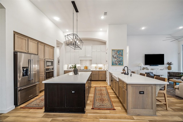 8818 Laurel Crest Dr, Missouri City, TX 77459 - kitchen with stainless steel appliances, light wood-style flooring, a sink, open floor plan, and light countertops