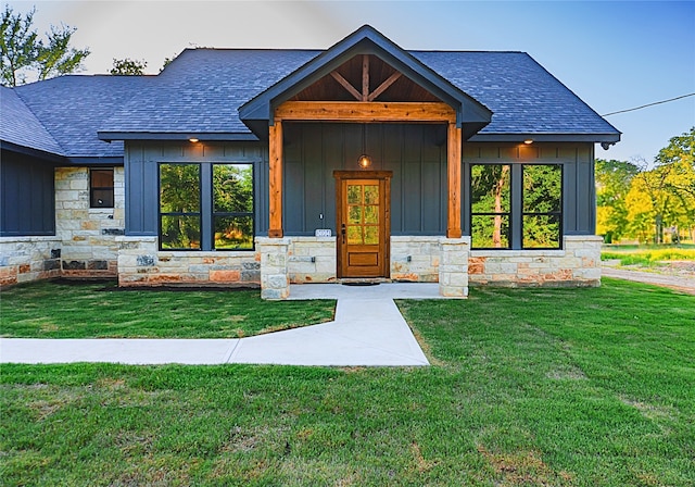 24994 Armagh St, Hempstead, TX 77445 - view of front of home featuring a shingled roof, stone siding, board and batten siding, and a front yard