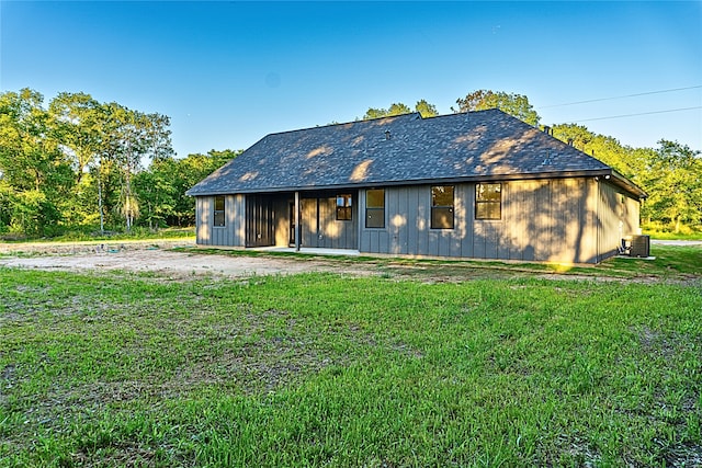 24994 Armagh St, Hempstead, TX 77445 - back of property with central AC unit, a lawn, and board and batten siding