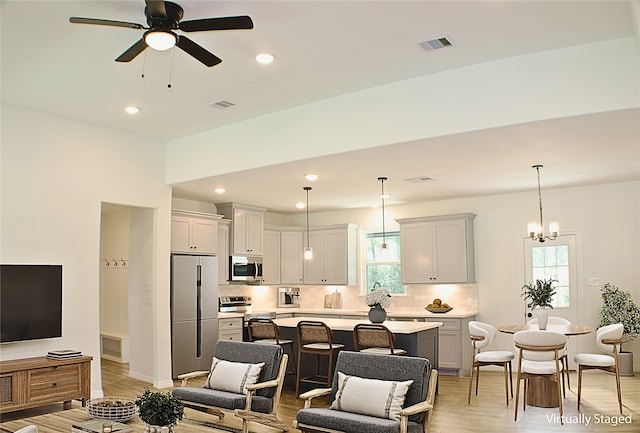 24994 Armagh St, Hempstead, TX 77445 - living area featuring light wood-type flooring, ceiling fan, recessed lighting, and a chandelier