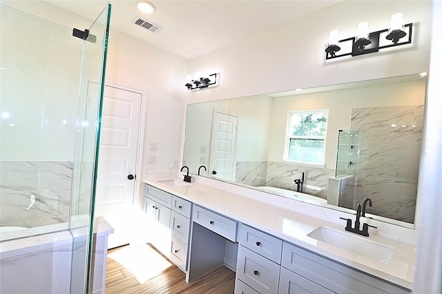 24994 Armagh St, Hempstead, TX 77445 - full bathroom featuring double vanity, a marble finish shower, wood finished floors, and a tub to relax in