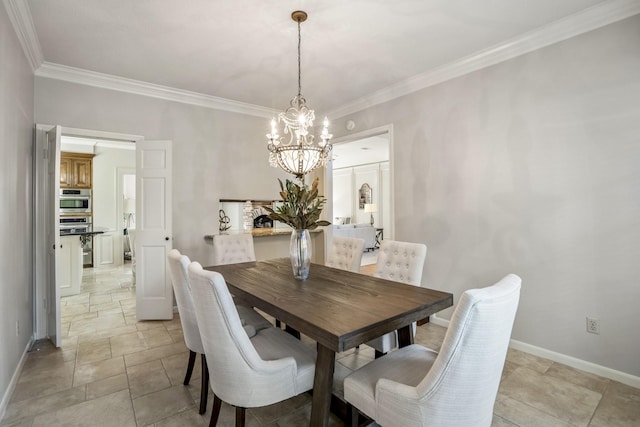dining area featuring baseboards, ornamental molding, and a chandelier