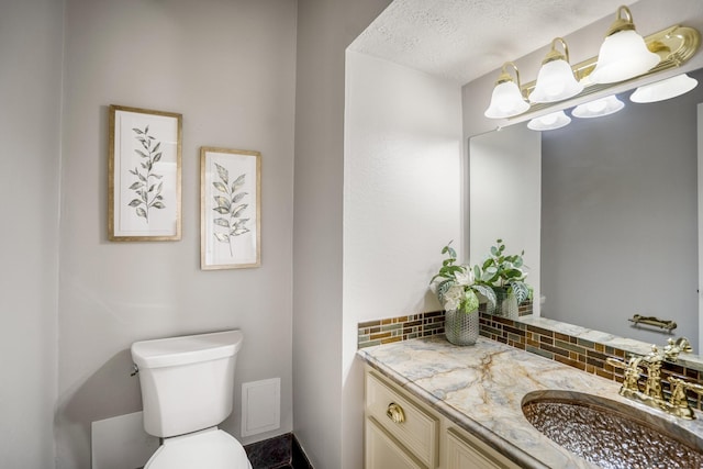 half bathroom with toilet, decorative backsplash, and vanity