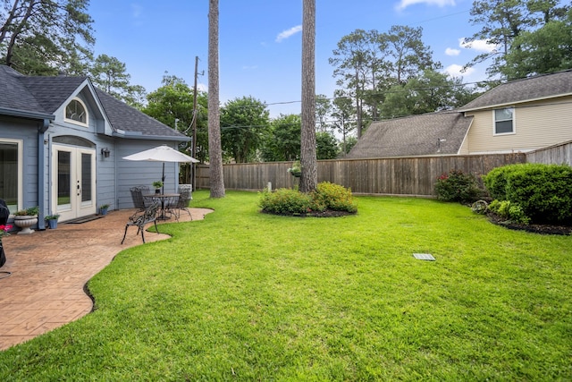 view of yard with french doors, a fenced backyard, and a patio area
