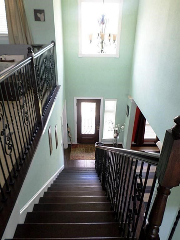 115 Shadow Springs Trl, Magnolia, TX 77354 - staircase with a chandelier, wood-type flooring, plenty of natural light, and a towering ceiling