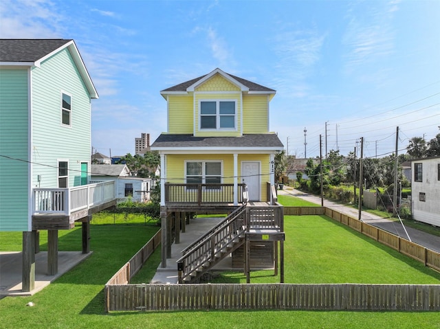 rear view of property featuring a lawn, a shingled roof, and a fenced backyard