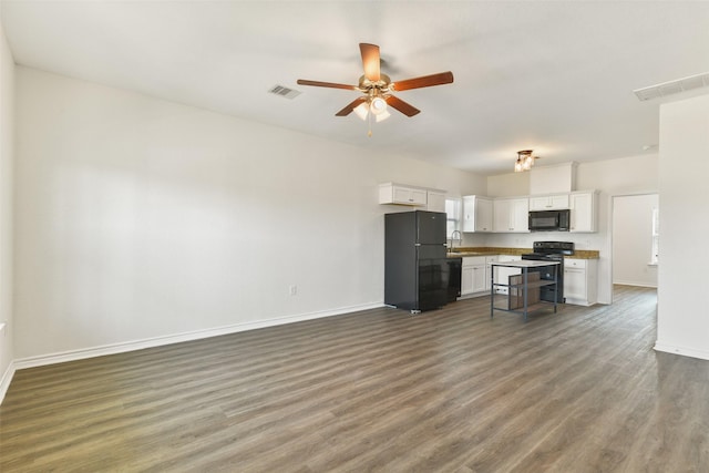 kitchen with open floor plan, baseboards, visible vents, and black appliances