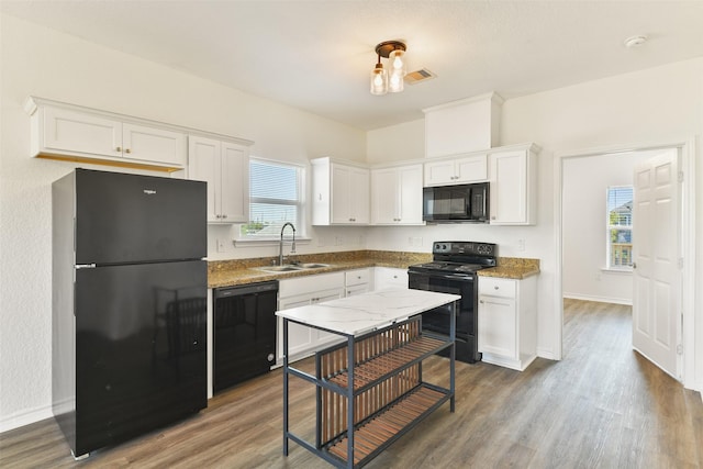kitchen featuring dark wood-style floors, a sink, and black appliances