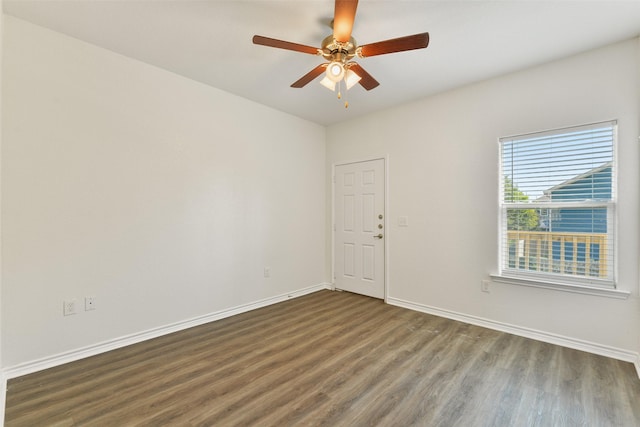 spare room featuring wood finished floors, baseboards, and ceiling fan