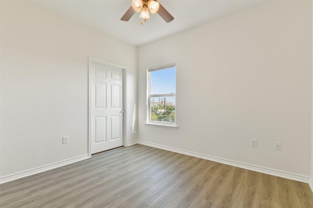 unfurnished room featuring baseboards, a ceiling fan, and wood finished floors