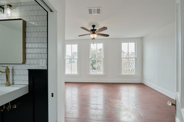 1323 Ball, Galveston, TX 77550 - unfurnished living room featuring wood-type flooring, baseboards, and a ceiling fan