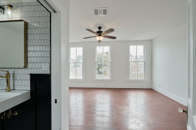 1323 Ball, Galveston, TX 77550 - unfurnished dining area with wood-type flooring, baseboards, ceiling fan, and a sink