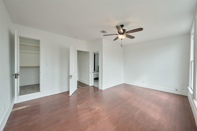 bedroom with ensuite bathroom, visible vents, baseboards, wood finished floors, and ceiling fan