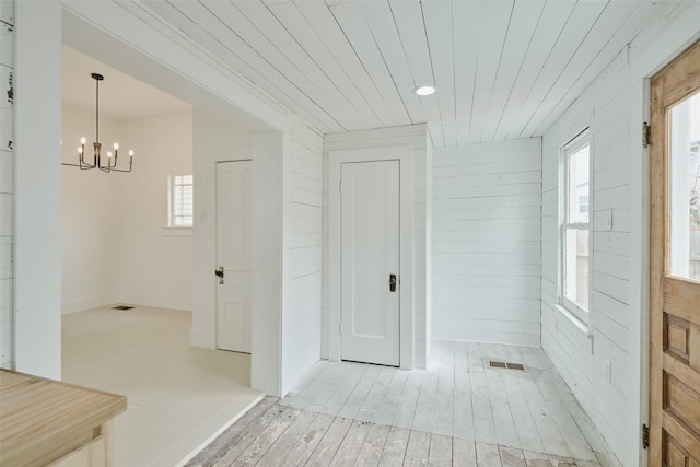 staircase with a wainscoted wall, wood finished floors, and wooden walls