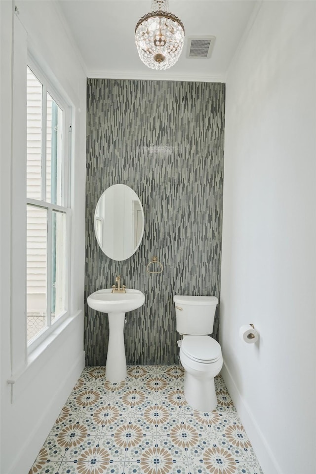 1323 Ball, Galveston, TX 77550 - half bath featuring baseboards, plenty of natural light, an accent wall, and crown molding