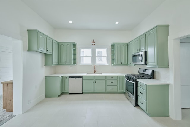 kitchen featuring open shelves, green cabinetry, stainless steel appliances, and a sink