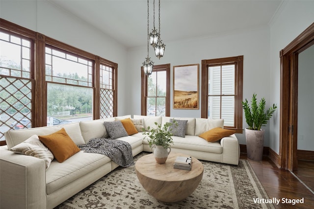 living area with wood finished floors, a wealth of natural light, and crown molding