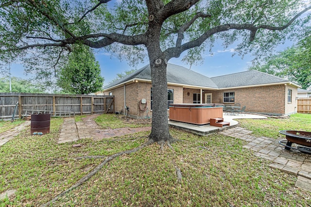 6249 Mallard Dr, Katy, TX 77493 - rear view of house with an outdoor fire pit, a fenced backyard, a hot tub, a patio, and brick siding