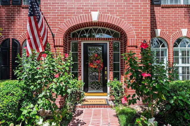 entrance to property featuring brick siding