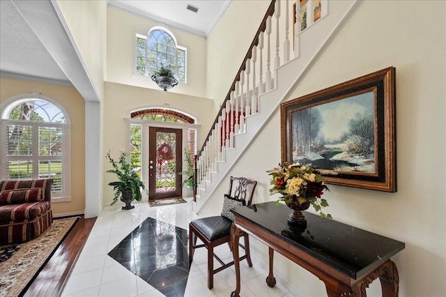 entrance foyer with visible vents, ornamental molding, and stairs