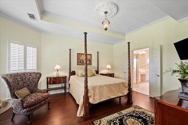 bedroom featuring dark wood finished floors, an inviting chandelier, connected bathroom, visible vents, and crown molding