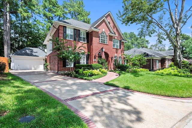 colonial inspired home with a garage, brick siding, an outdoor structure, and a front yard